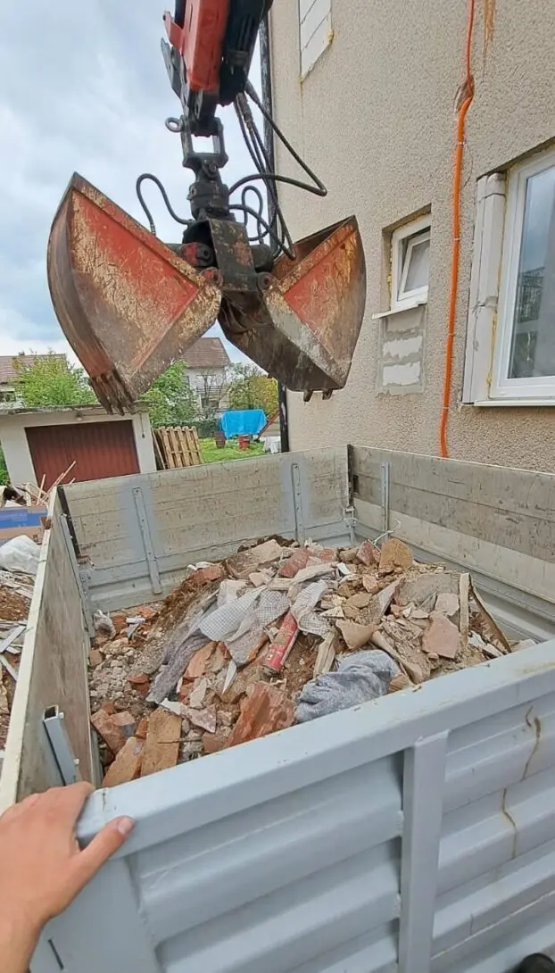 Grajfer iznad sanduka kamiona punog šute